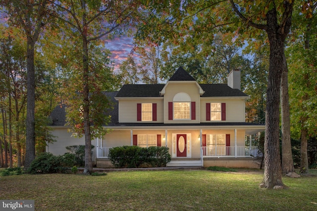 view of front of property featuring covered porch and a lawn