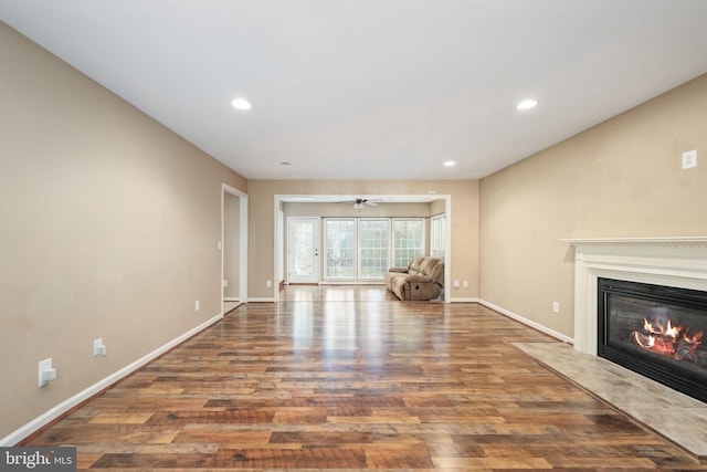 unfurnished living room featuring wood-type flooring and ceiling fan