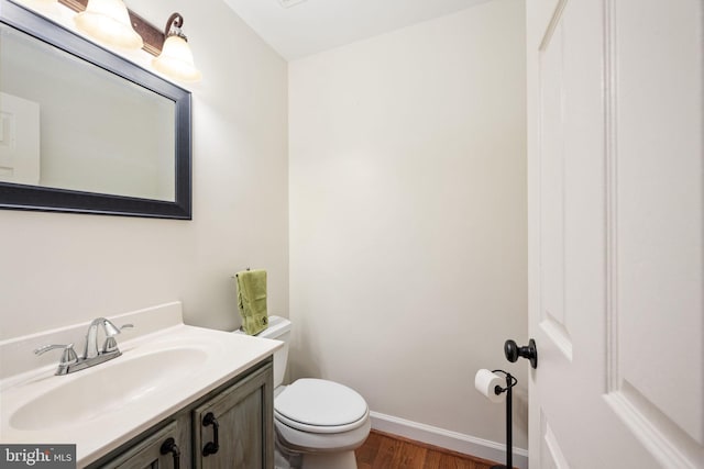 bathroom with vanity, toilet, and hardwood / wood-style floors