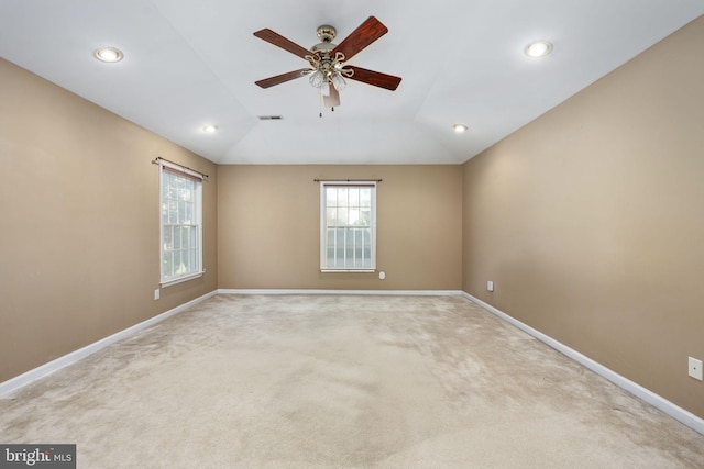 carpeted spare room featuring lofted ceiling and ceiling fan