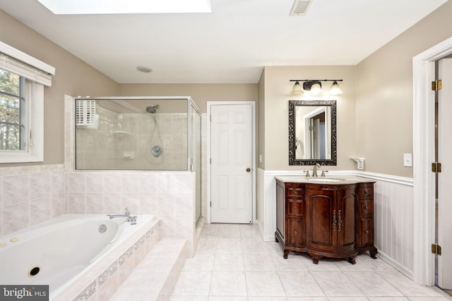 bathroom featuring vanity, independent shower and bath, a skylight, and tile patterned flooring