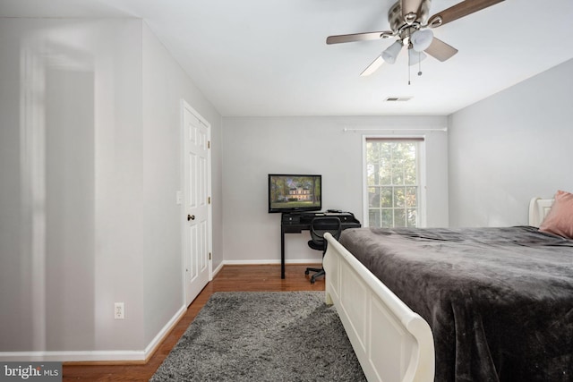 bedroom with dark hardwood / wood-style floors and ceiling fan