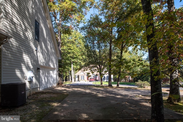 view of yard featuring a garage and central AC unit