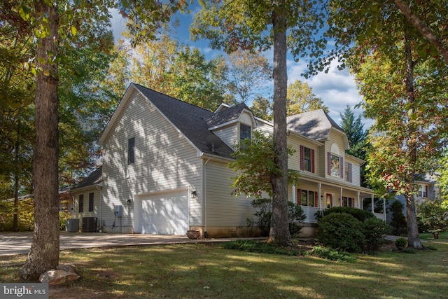 view of property exterior featuring central AC unit, a garage, and a lawn