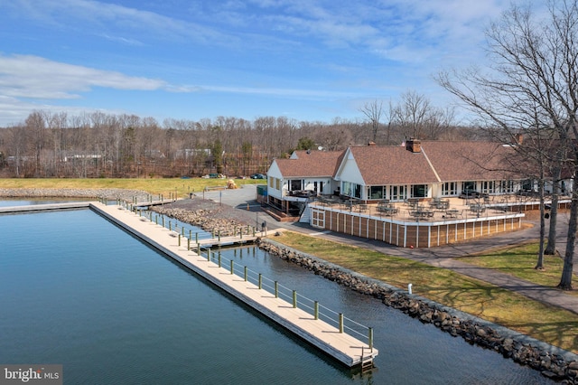 back of house featuring a water view, a patio area, and a yard