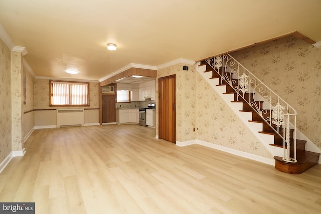 unfurnished living room featuring light hardwood / wood-style floors, radiator, and crown molding