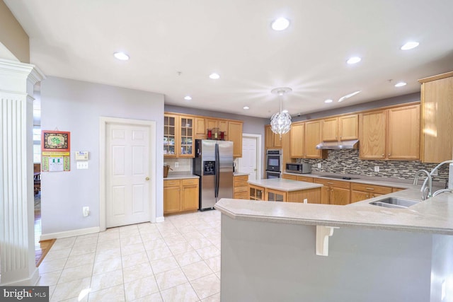 kitchen featuring sink, hanging light fixtures, backsplash, a kitchen island, and appliances with stainless steel finishes