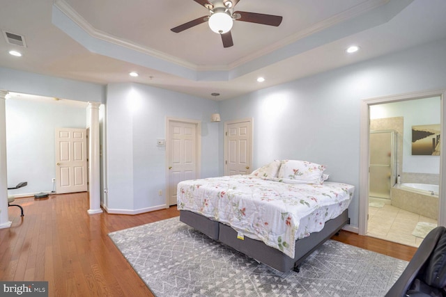 bedroom featuring a tray ceiling, crown molding, ceiling fan, and dark wood-type flooring