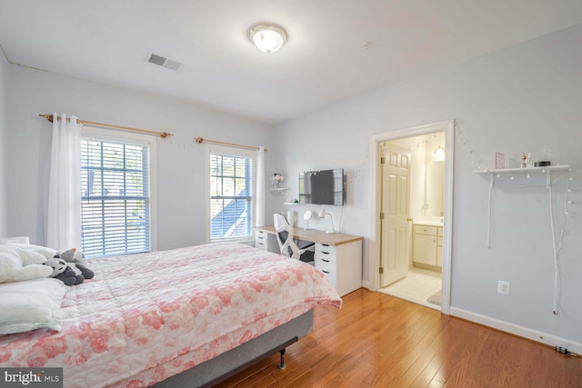 bedroom featuring hardwood / wood-style flooring and connected bathroom