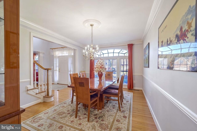 dining area featuring an inviting chandelier, crown molding, and light hardwood / wood-style flooring