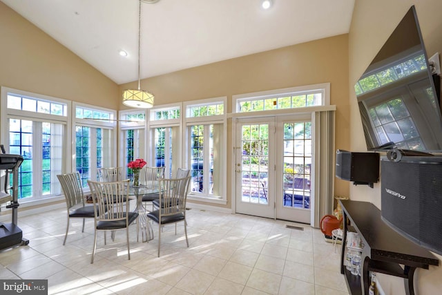 tiled dining space with high vaulted ceiling and a wealth of natural light