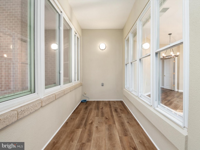 unfurnished sunroom featuring an inviting chandelier