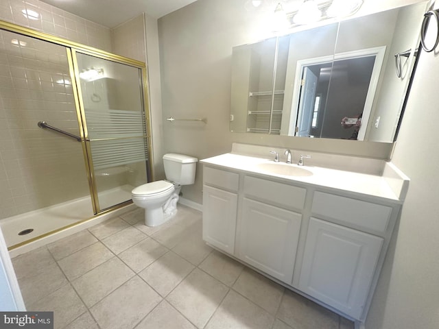 bathroom featuring tile patterned flooring, vanity, toilet, and a shower with door