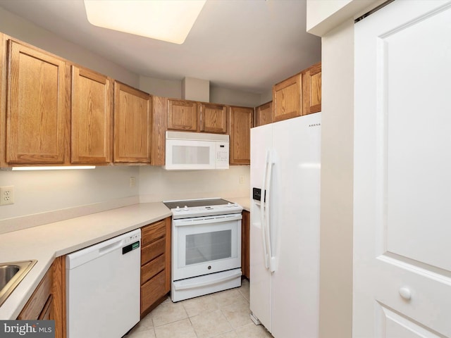 kitchen with white appliances, sink, and light tile patterned flooring