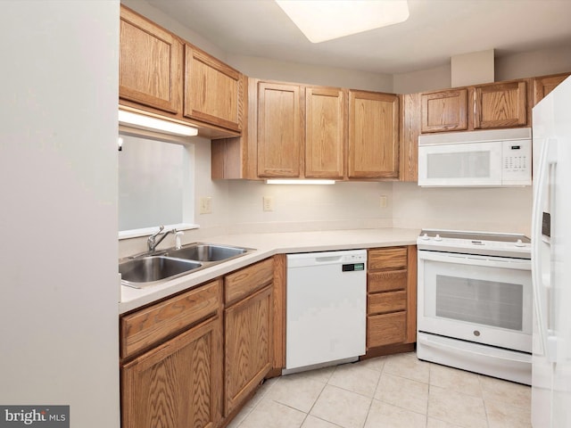 kitchen featuring light tile patterned floors, white appliances, and sink