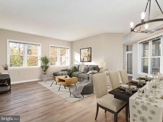 living room with light wood-type flooring and an inviting chandelier