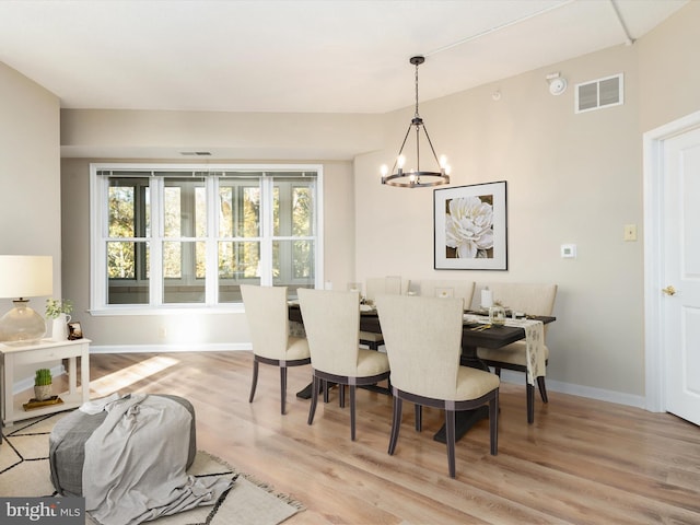 dining space featuring light hardwood / wood-style flooring and an inviting chandelier