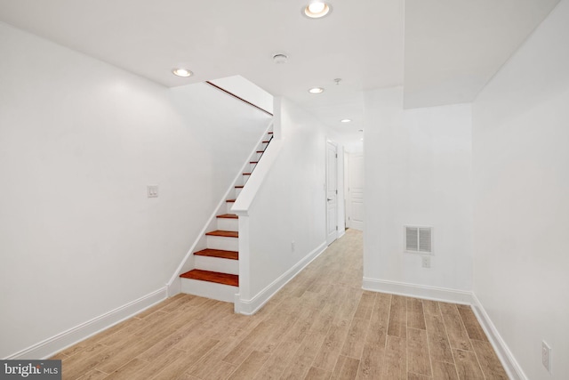 staircase with hardwood / wood-style floors