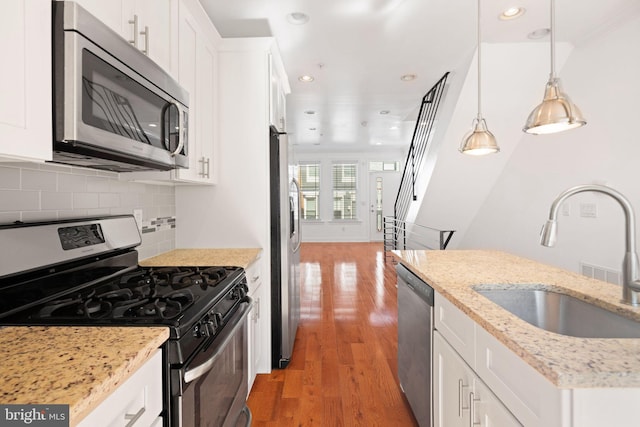 kitchen featuring appliances with stainless steel finishes, sink, and white cabinets