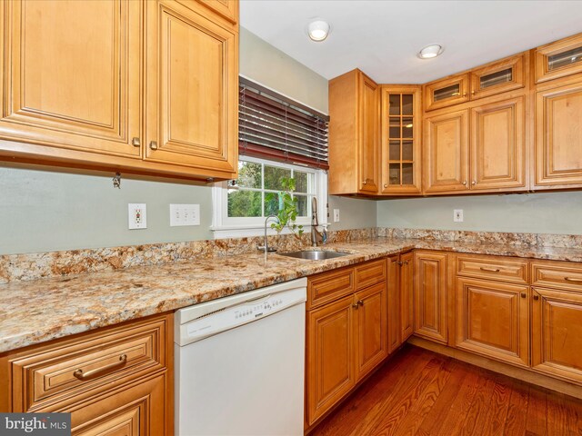 kitchen featuring light stone counters, dark wood-type flooring, sink, and dishwasher