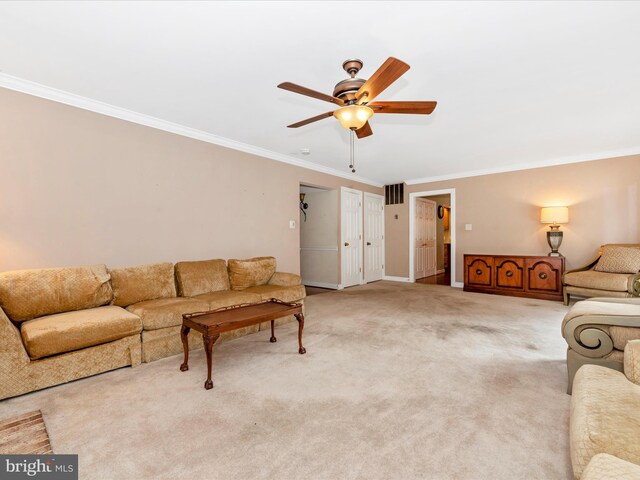 carpeted living room with ornamental molding and ceiling fan