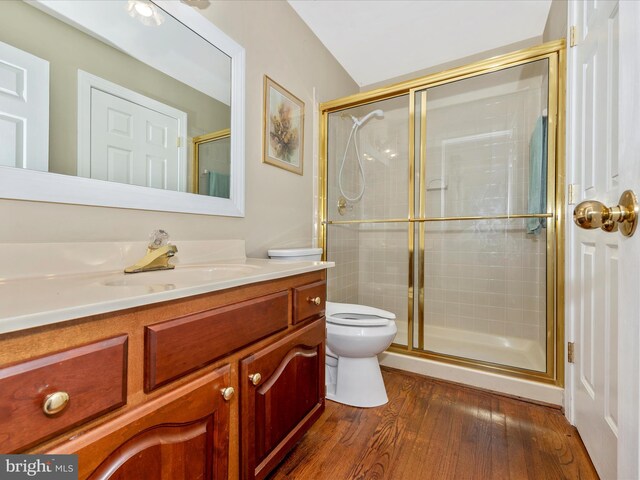 bathroom with a shower with door, hardwood / wood-style flooring, vanity, and toilet