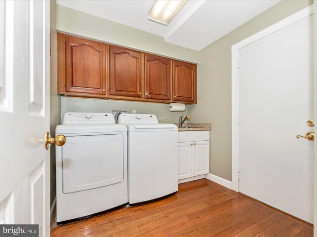 washroom featuring separate washer and dryer, cabinets, light wood-type flooring, and sink