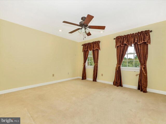 carpeted empty room featuring ceiling fan and a healthy amount of sunlight