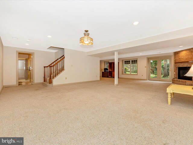 unfurnished living room featuring a brick fireplace and light colored carpet