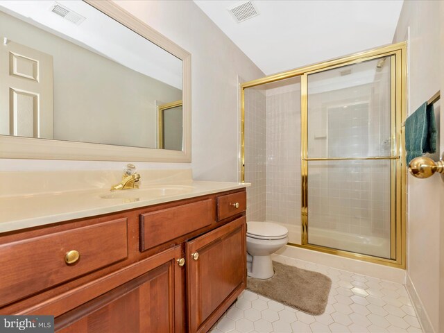 bathroom featuring tile patterned flooring, walk in shower, vanity, and toilet