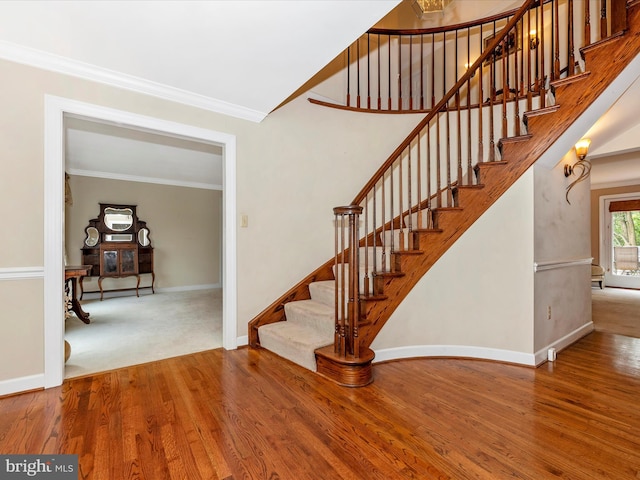 staircase with crown molding and hardwood / wood-style floors