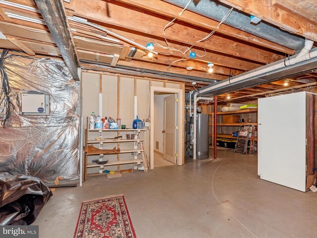 basement with water heater and white fridge