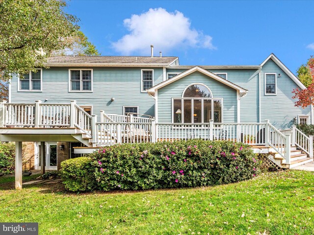 back of house featuring a deck and a lawn