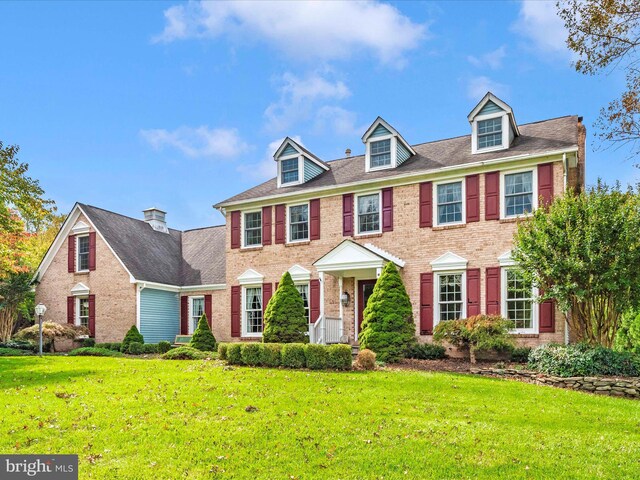 colonial inspired home featuring a front lawn