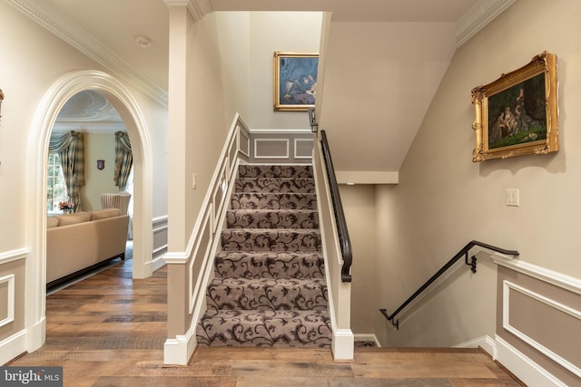 stairway featuring ornamental molding and hardwood / wood-style flooring