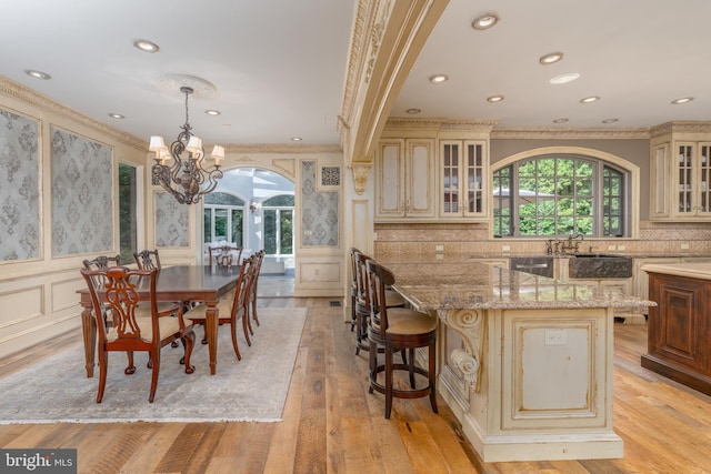 kitchen with pendant lighting, cream cabinets, and plenty of natural light