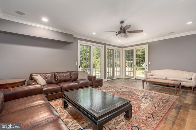 living room with dark wood-type flooring, crown molding, and ceiling fan