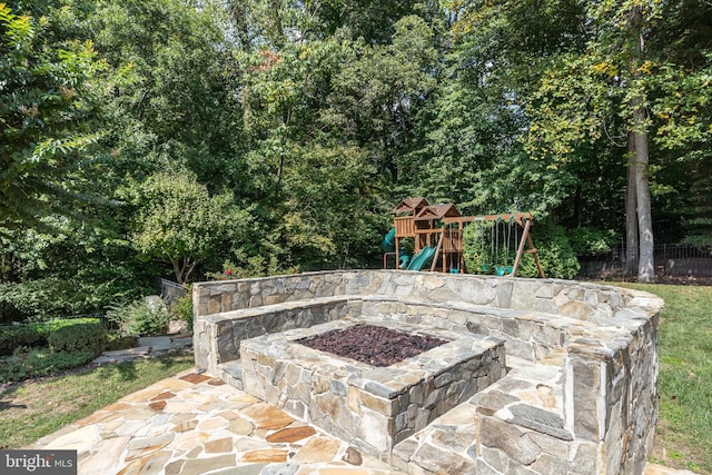 view of patio featuring a playground and a fire pit