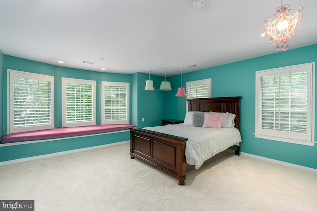 bedroom featuring light colored carpet and a notable chandelier