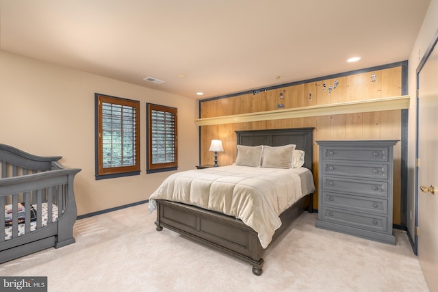 carpeted bedroom featuring wooden walls