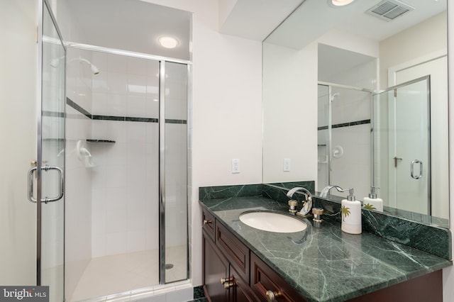 bathroom with a shower with door and vanity