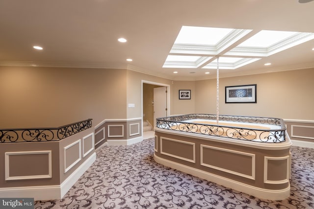 interior space with a skylight, crown molding, coffered ceiling, and light colored carpet