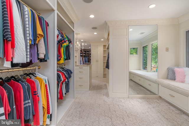 spacious closet with a chandelier