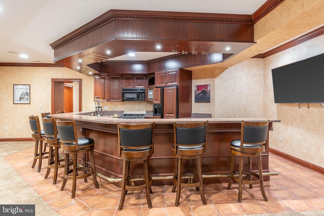 bar with ornamental molding and paneled fridge