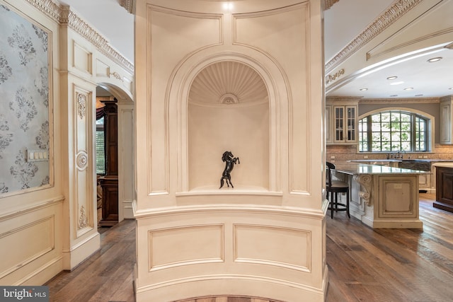 corridor with ornamental molding, sink, and dark hardwood / wood-style flooring