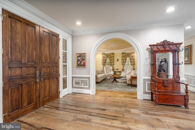 entryway featuring light wood-type flooring and ornamental molding