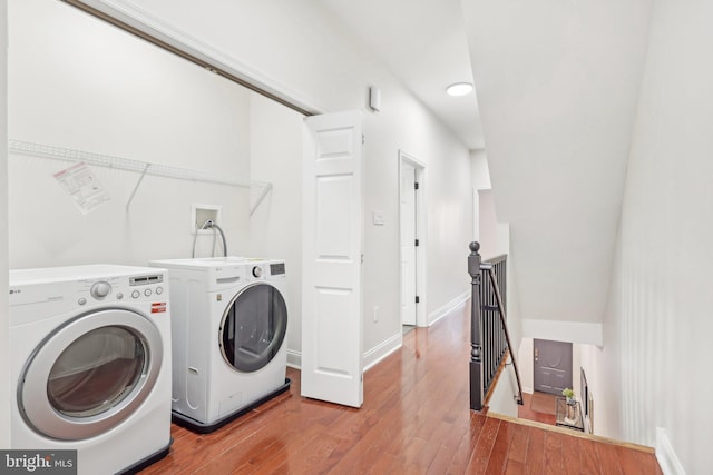 washroom with hardwood / wood-style flooring and washer and clothes dryer