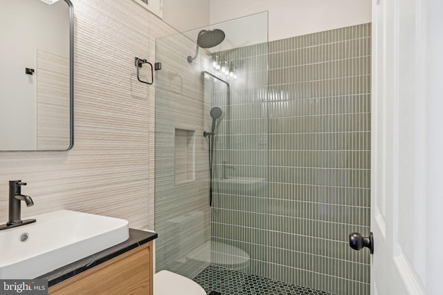 bathroom with backsplash, toilet, tile walls, tiled shower, and vanity