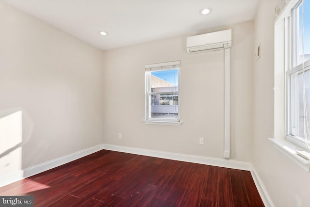 empty room with hardwood / wood-style floors and a wall mounted AC