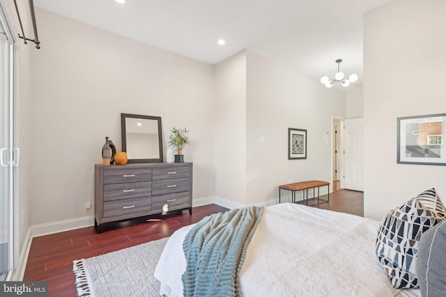 bedroom featuring dark wood-type flooring, a notable chandelier, and a towering ceiling